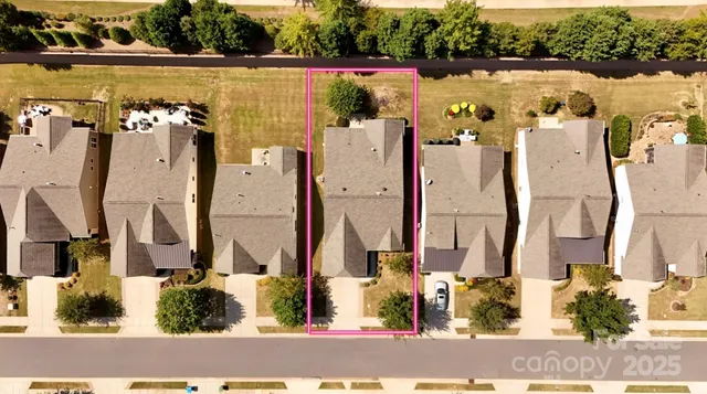 an aerial view of residential houses with outdoor space and parking