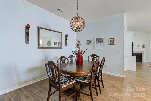a dining room with furniture a chandelier and wooden floor