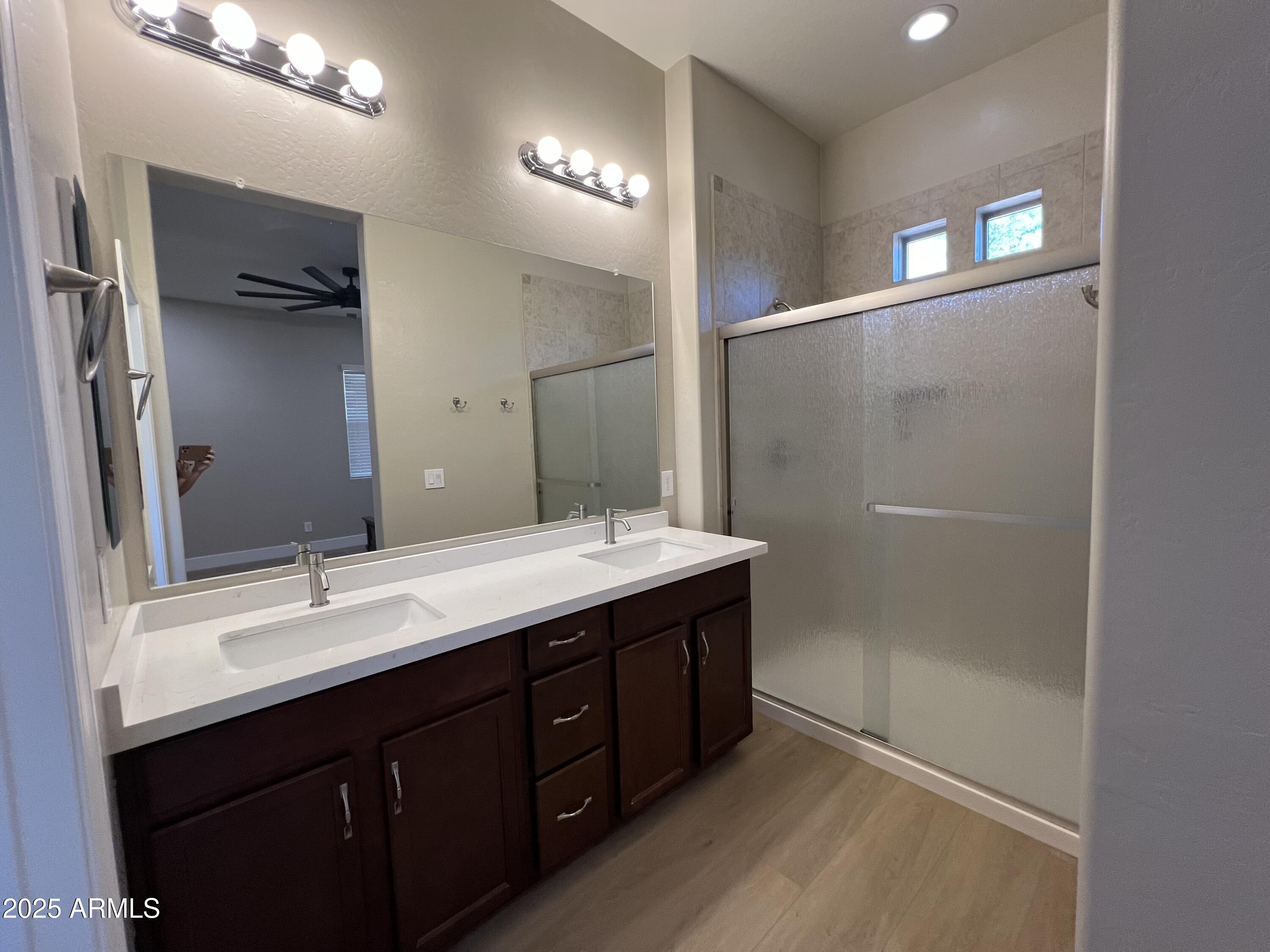 20480 West Point Ridge Road Buckeye, AZ 85396 - Photo 12 of 16 a bathroom with a double vanity sink and mirror with shower