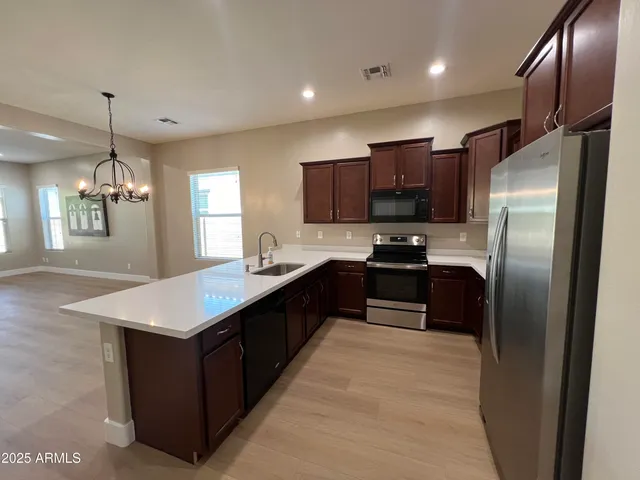 a kitchen with stainless steel appliances granite countertop a refrigerator a sink and a stove