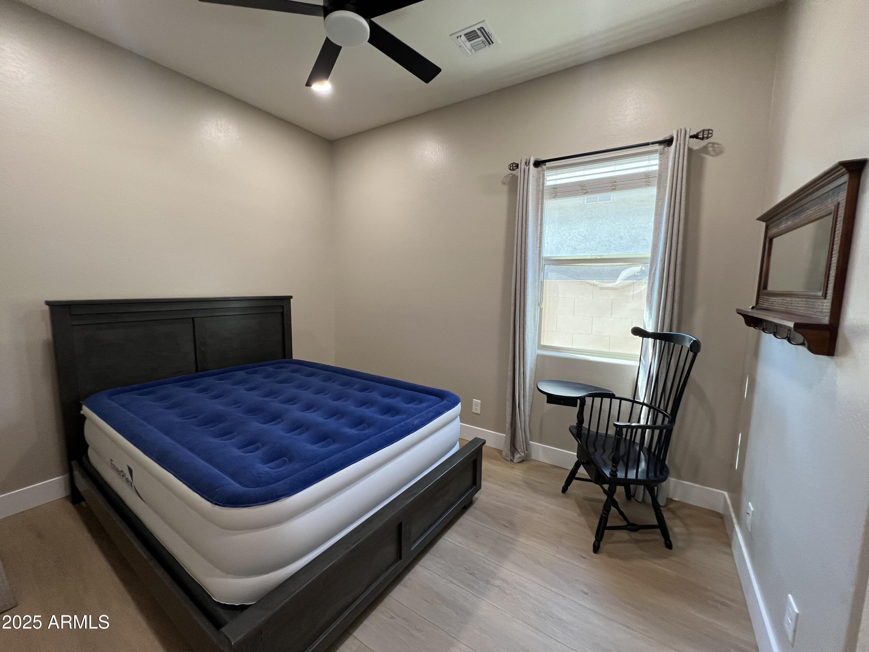 20480 West Point Ridge Road Buckeye, AZ 85396 - Photo 7 of 16 a bedroom with a bed and chair