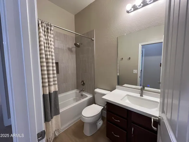 a bathroom with a sink a toilet a mirror and shower