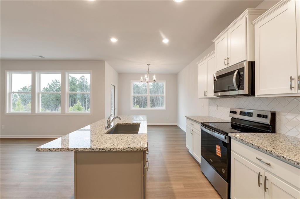 106 Windmill Court Calhoun, GA 30701 - Photo 6 of 29 a kitchen with stainless steel appliances granite countertop a stove a sink and a microwave