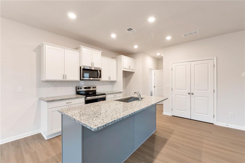 106 Windmill Court Calhoun, GA 30701 - Photo 9 of 29 a kitchen with granite countertop a sink and stainless steel appliances