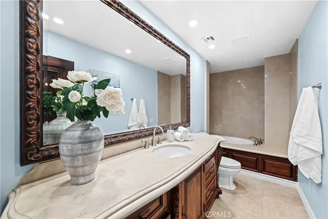 a bathroom with a granite countertop tub a sink and a window