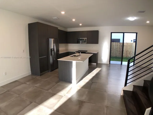 a kitchen with stainless steel appliances granite countertop a refrigerator a stove and a refrigerator