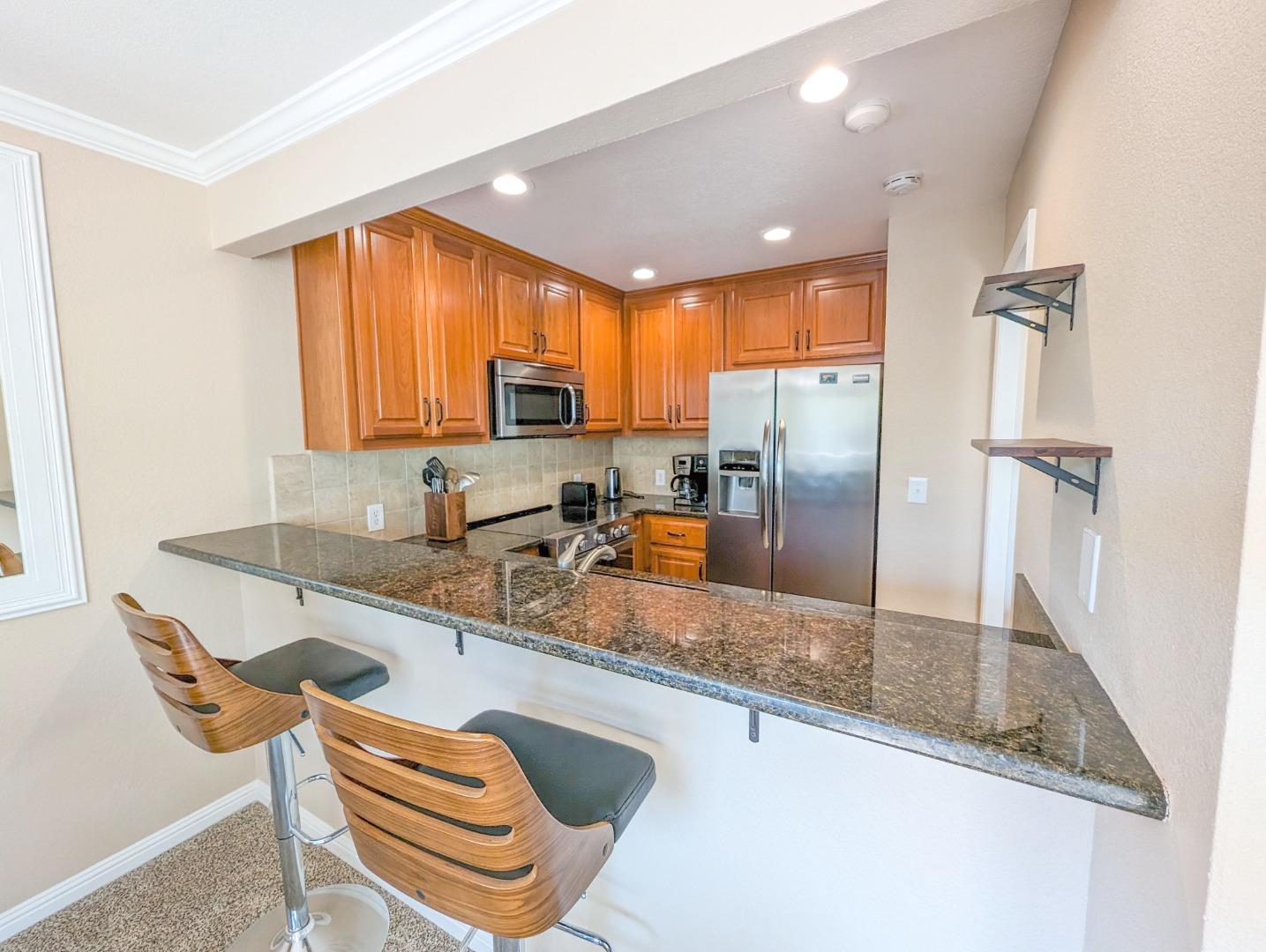 205 Compton Circle, Unit B San Ramon, CA 94583 - Photo 10 of 24 a kitchen with granite countertop a sink a counter top space cabinets stainless steel appliances and a window