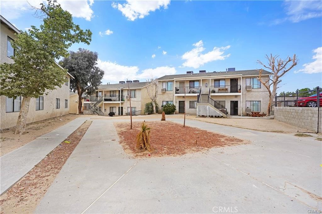17802 Quantico Road Apple Valley, CA 92307 - Photo 12 of 21 a front view of a building with a garden and tree