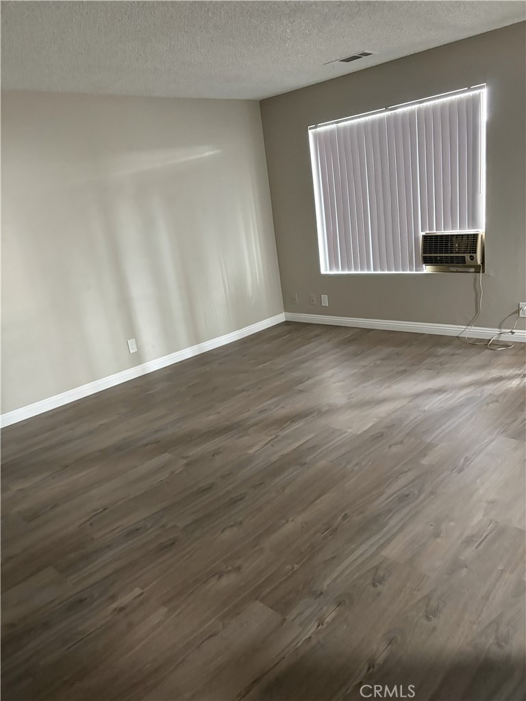17802 Quantico Road Apple Valley, CA 92307 - Photo 8 of 21 an empty room with wooden floor and windows