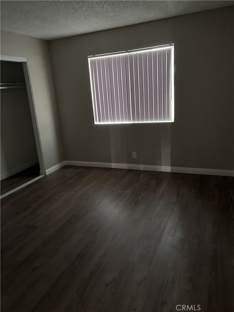 17802 Quantico Road Apple Valley, CA 92307 - Photo 9 of 21 an empty room with wooden floor and windows