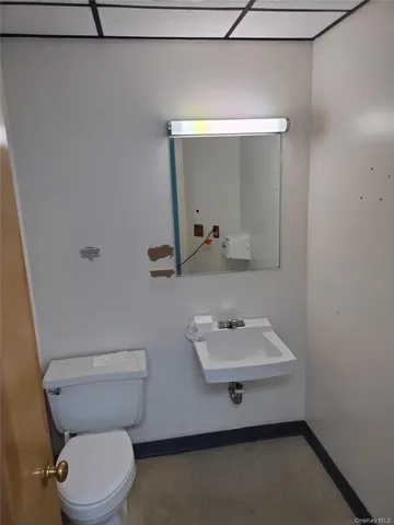 a bathroom with a sink a toilet and mirror