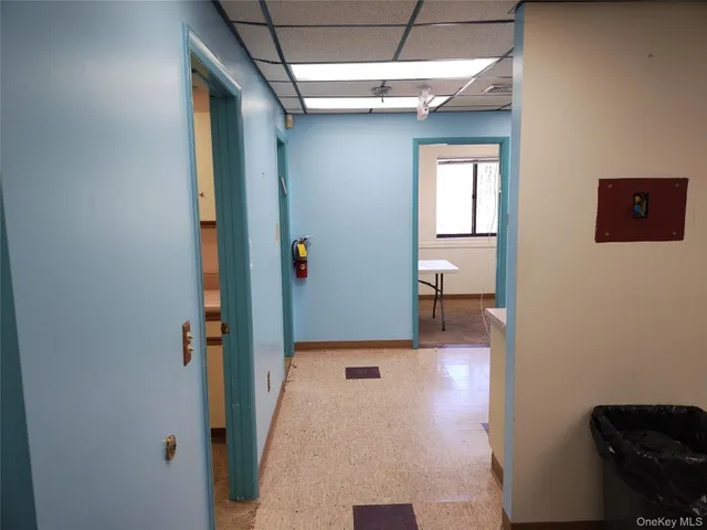 a view of a hallway with wooden floor and a living room