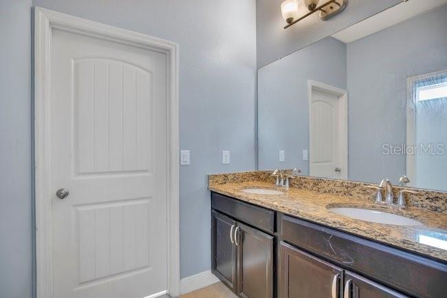 1422 Sharon Rose Trace Deltona, FL 32725 - Photo 35 of 42 a bathroom with a granite countertop sink and a mirror