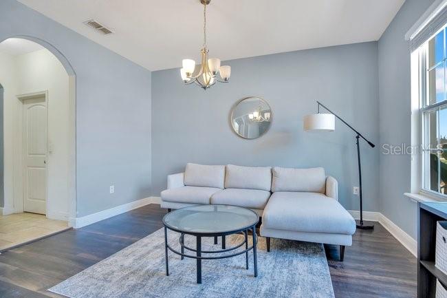 1422 Sharon Rose Trace Deltona, FL 32725 - Photo 37 of 42 a living room with furniture a dining table and a chandelier