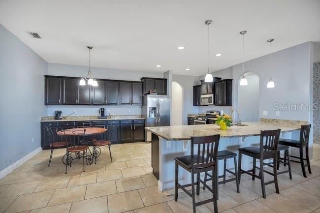 1422 Sharon Rose Trace Deltona, FL 32725 - Photo 7 of 42 a kitchen with a dining table chairs and white cabinets