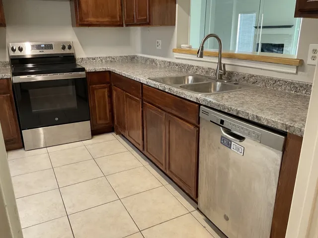 a kitchen with a sink a stove and cabinets