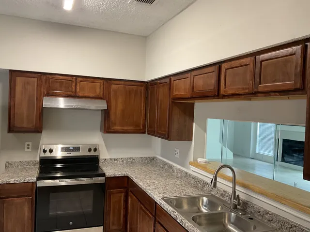 a kitchen with granite countertop a sink and a stove top oven