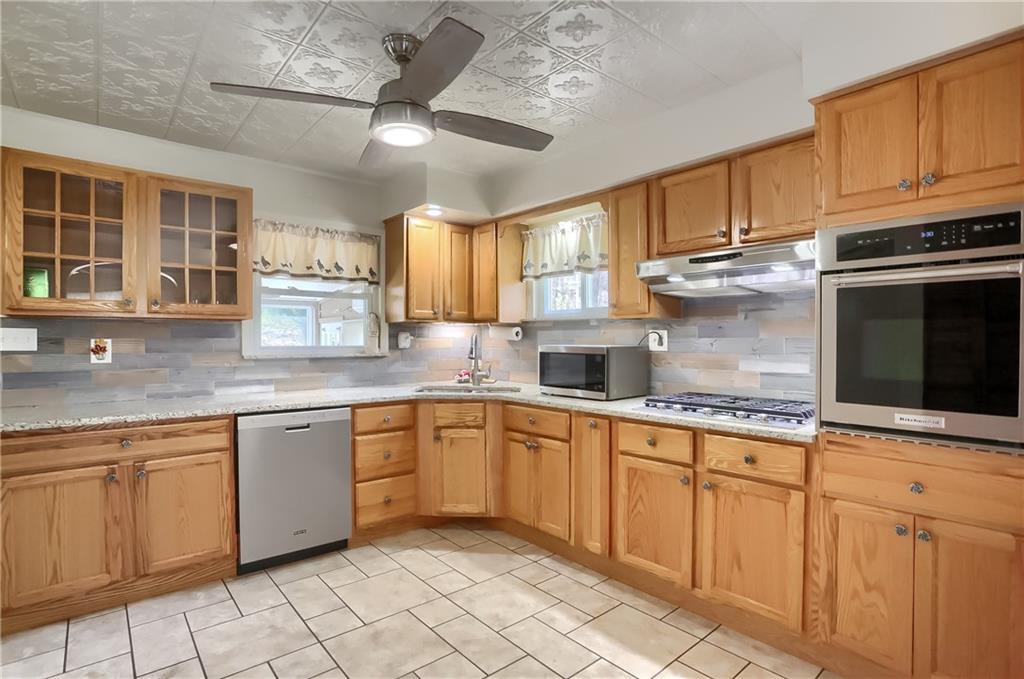 1225 Stitts Run Road Vandergrift, PA 15690 - Photo 7 of 45 a kitchen with granite countertop white cabinets a sink and appliances