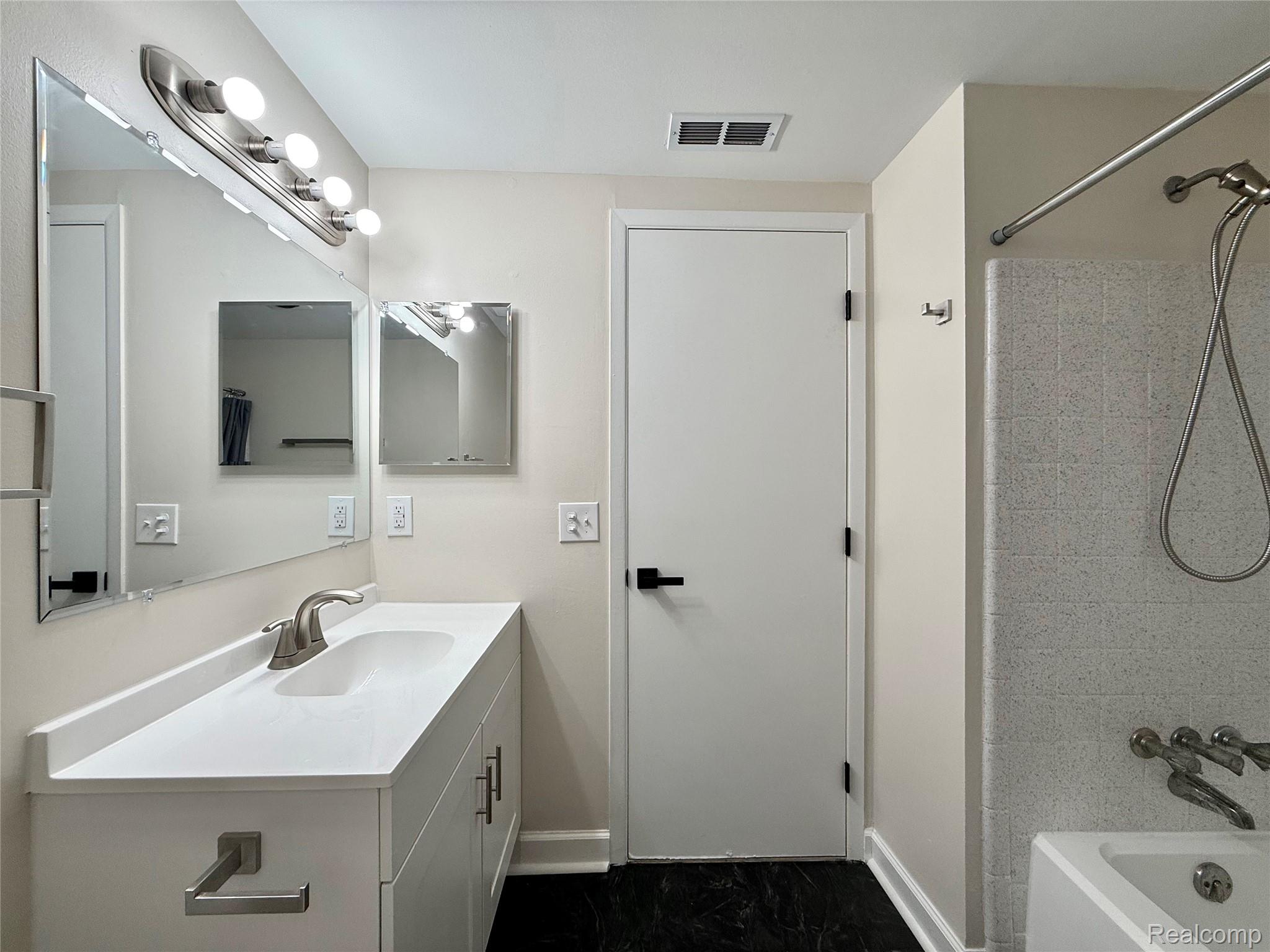 29870 West 12 Mile Road, Unit 703 Farmington, MI 48334 - Photo 15 of 40 Bathroom featuring a white vanity with an integrated sink, brushed nickel faucet, large wall mirror, and a five-light vanity fixture