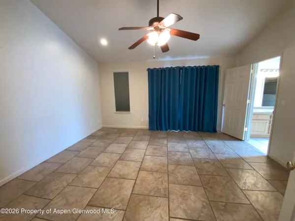 a view of an empty room with a chandelier fan