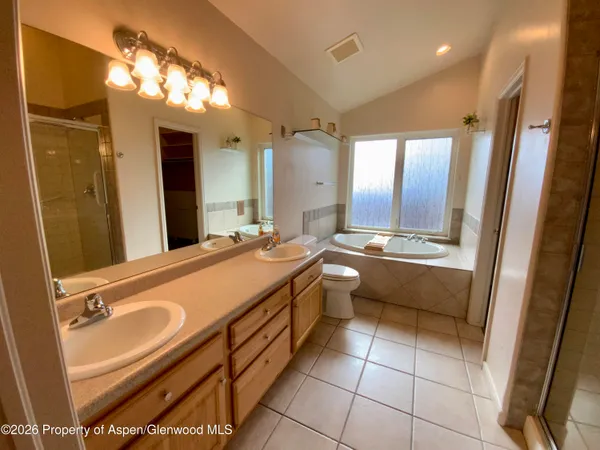 a spacious bathroom with a double vanity sink a mirror and a bathtub