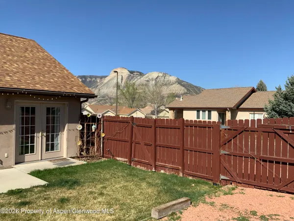 a view of a house with a wooden fence