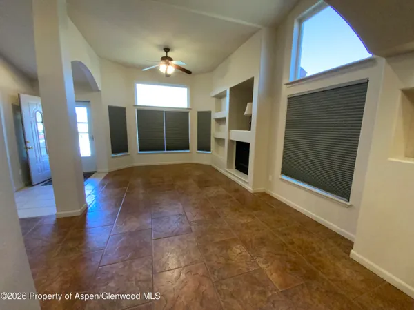 a view of an empty room with wooden floor and a fireplace