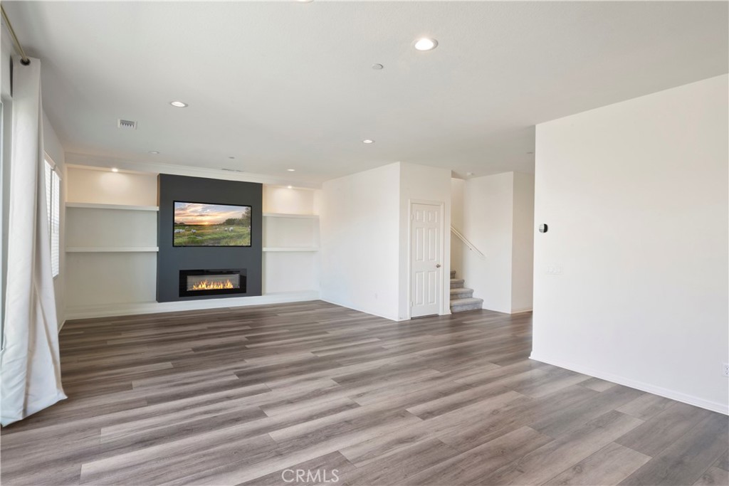 9605 Bonsai Lane Riverside, CA 92508 - Photo 12 of 41 a view of an empty room with wooden floor and a window