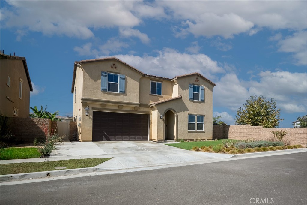 9605 Bonsai Lane Riverside, CA 92508 - Photo 4 of 41 a front view of a house with a yard and garage