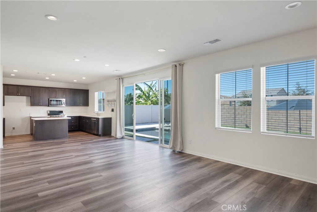 9605 Bonsai Lane Riverside, CA 92508 - Photo 9 of 41 a large kitchen with stainless steel appliances granite countertop a large cabinets and a wooden floor