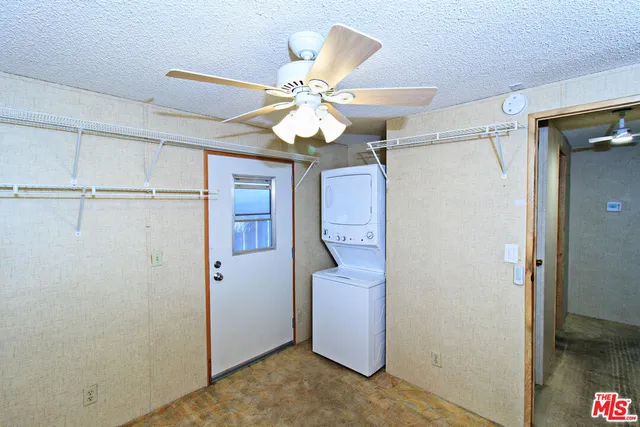 a view of a hallway with closet and chandelier fan
