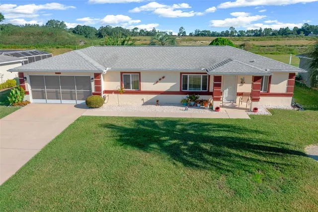 an aerial view of a house with patio swimming pool and a yard