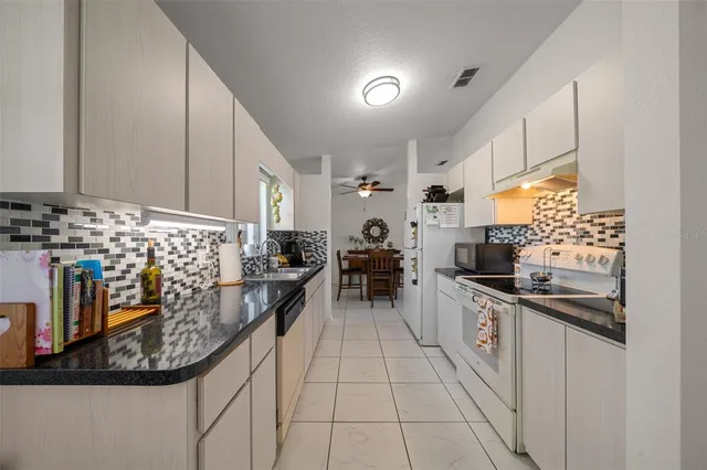 a kitchen with stainless steel appliances granite countertop a stove a sink and a refrigerator