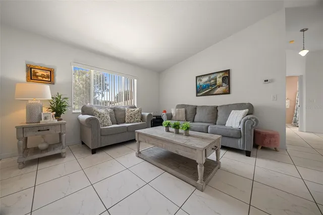 a living room with furniture a dining table and a potted plant