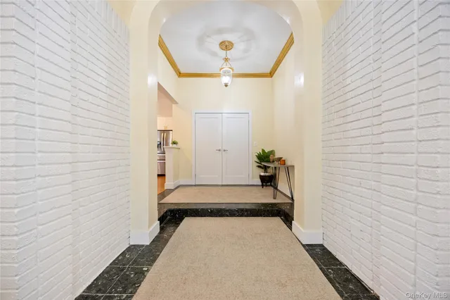 a view of a hallway with wooden door and staircase