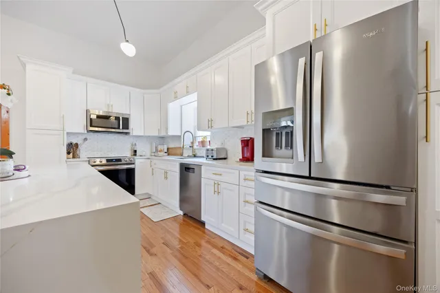 a kitchen with granite countertop stainless steel appliances and white cabinets