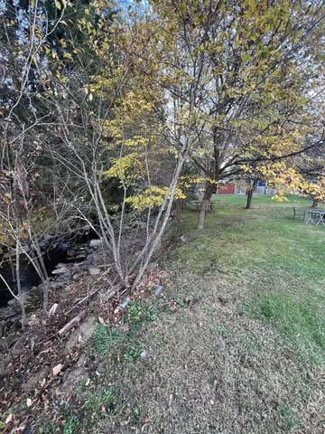 a view of field with trees in background
