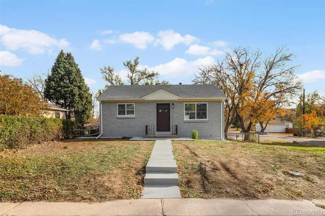 a front view of a house with a yard and trees