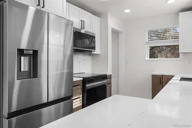 a kitchen with stainless steel appliances a refrigerator and a stove top oven