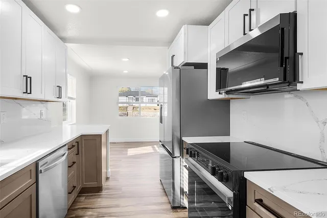 a kitchen with stainless steel appliances a stove microwave and sink