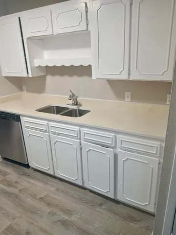 a kitchen with white cabinets white appliances and sink