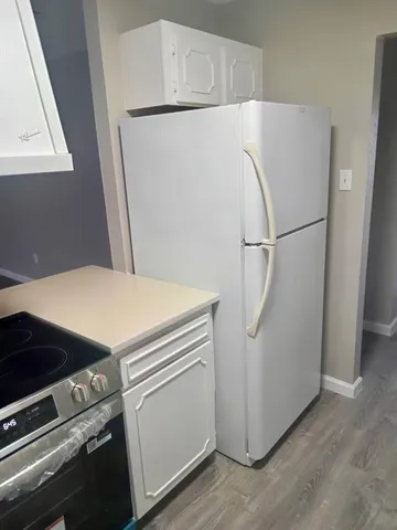 a white refrigerator freezer and a stove sitting inside of a kitchen