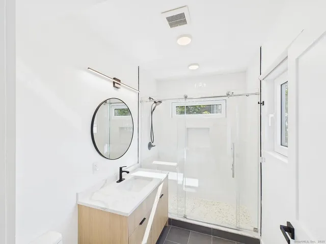 a bathroom with a sink a toilet and a mirror