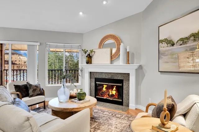 a living room with furniture a fireplace and a large window