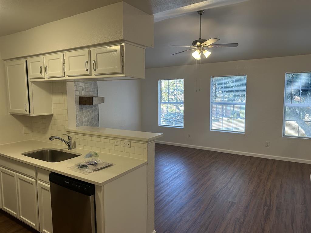 2400 Jupiter Road, Unit D2 Plano, TX 75074 - Photo 6 of 17 Kitchen featuring white cabinetry, tasteful backsplash, dishwasher, and dark wood finished floors