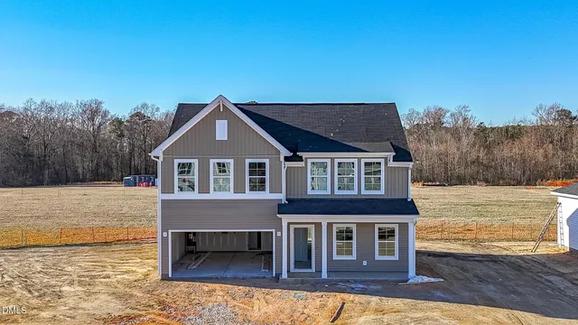 a front view of a house with a garden and lake view