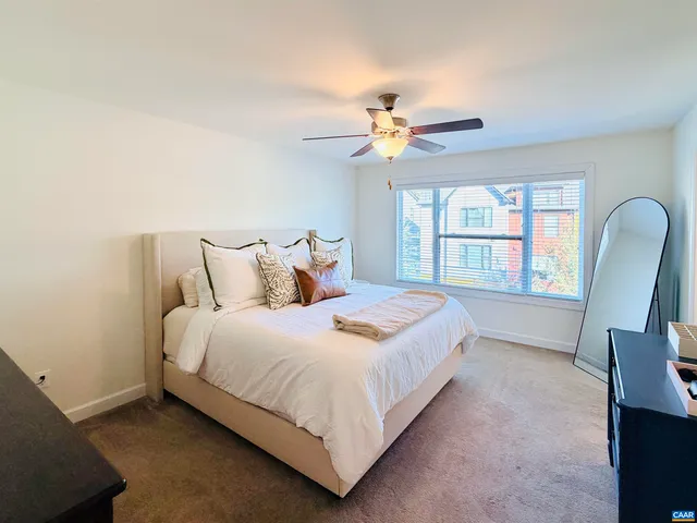 a bedroom with a bed a chandelier and a window