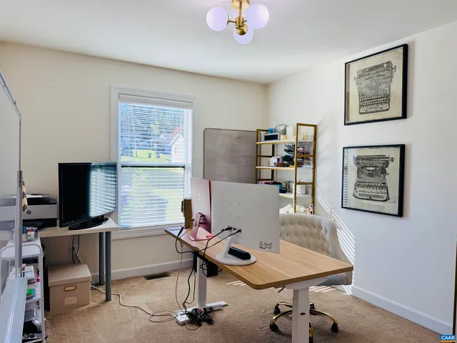 a view of a workspace with furniture and a window