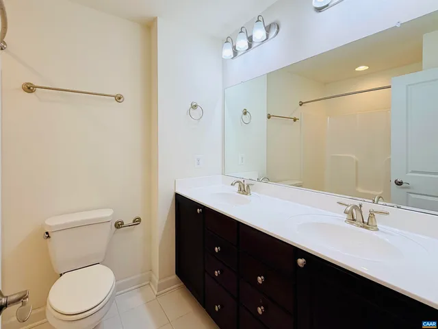 a bathroom with a toilet a sink a mirror and a shower