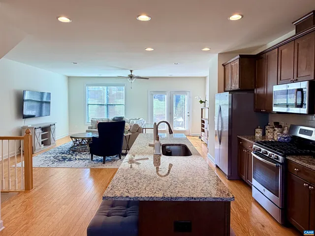 a kitchen with stainless steel appliances granite countertop a stove refrigerator sink and cabinets